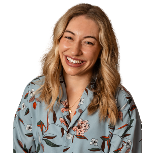 Smiling woman with wavy hair wearing a floral print shirt.