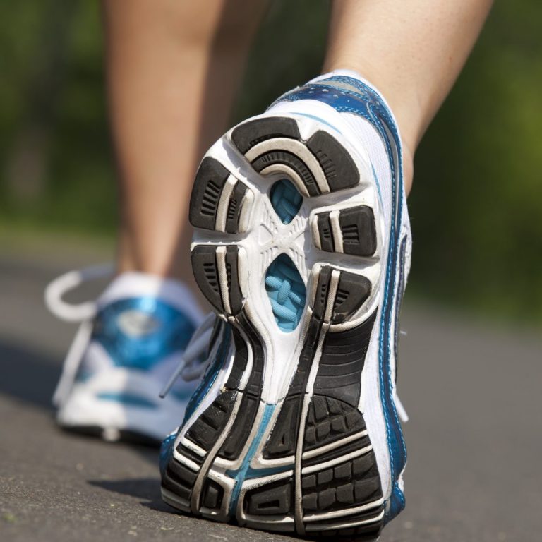 Close-up of the sole of a running shoe on a paved surface.